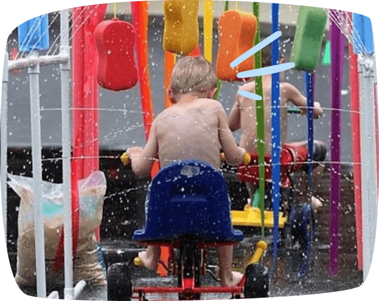 criança a passar com um triciclo por uma lavagem 